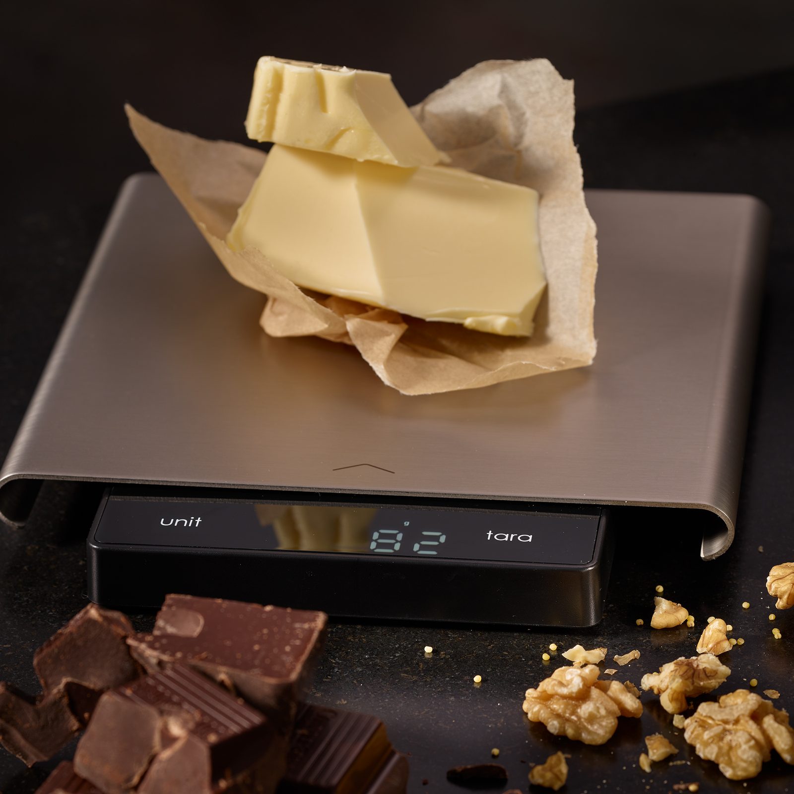 Real Rösle digital kitchen scale weighing butter in grams, with its sliding display visible in front of the weighing platform